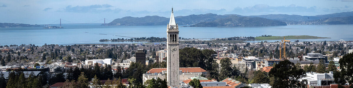 A view of Berkeley with the Campanile tower in the foreground and Golden Gate Bridge in the distance.